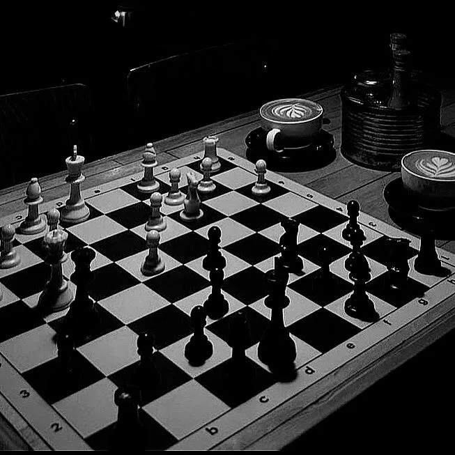 A chessboard and two coffees on a table