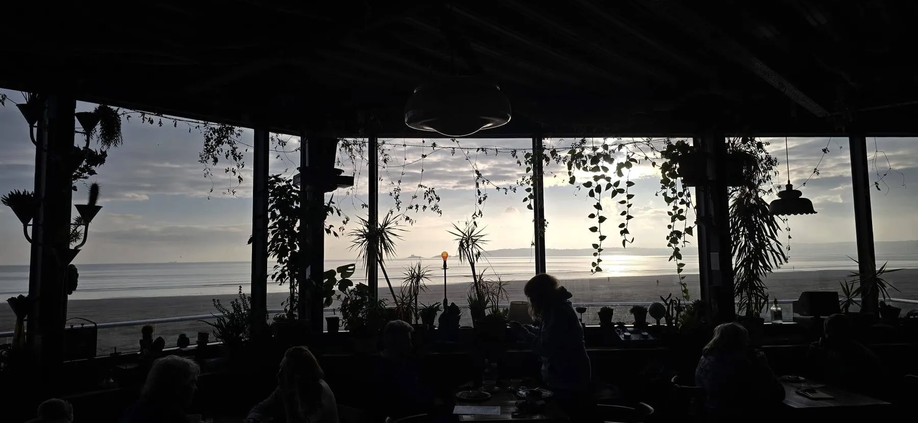 The dining room at dusk with the bay behind